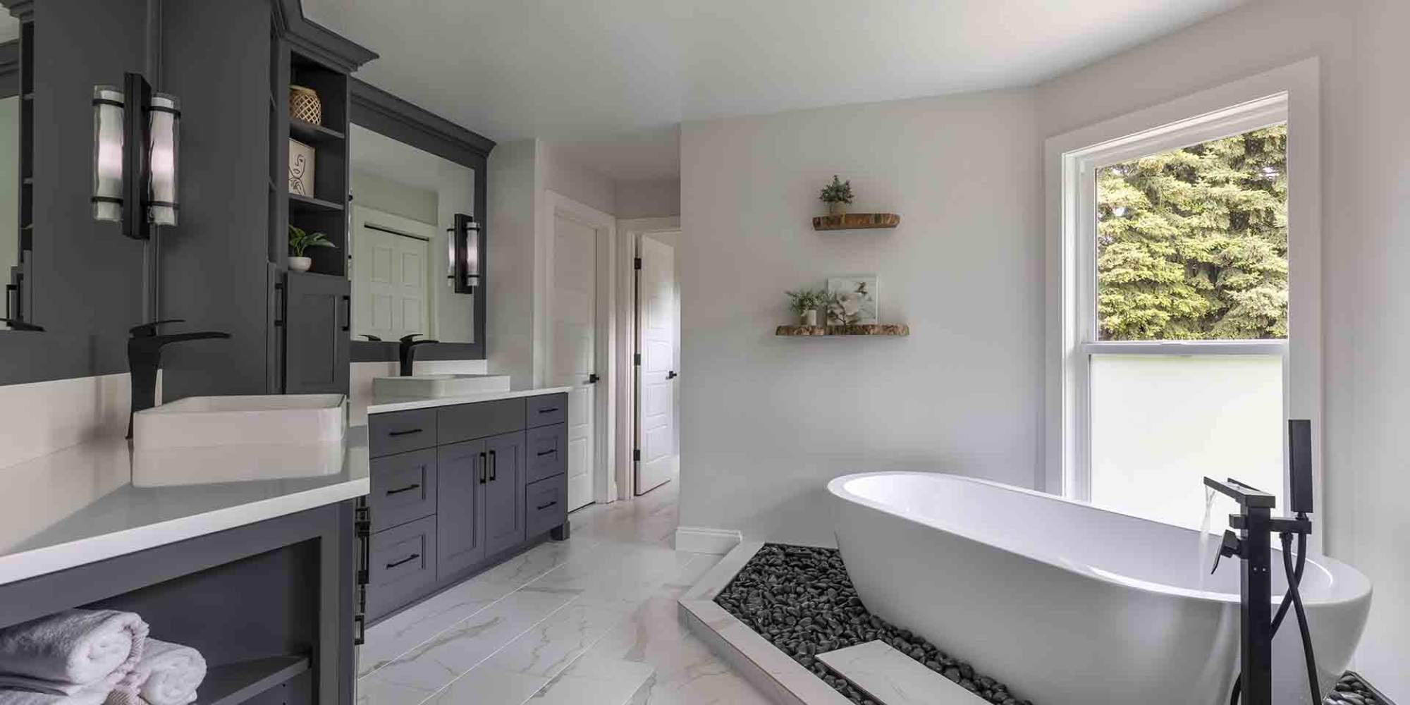 Image of a remodeled bathroom in Beaverton with stand-alone tub and dual vanity by Creekstone