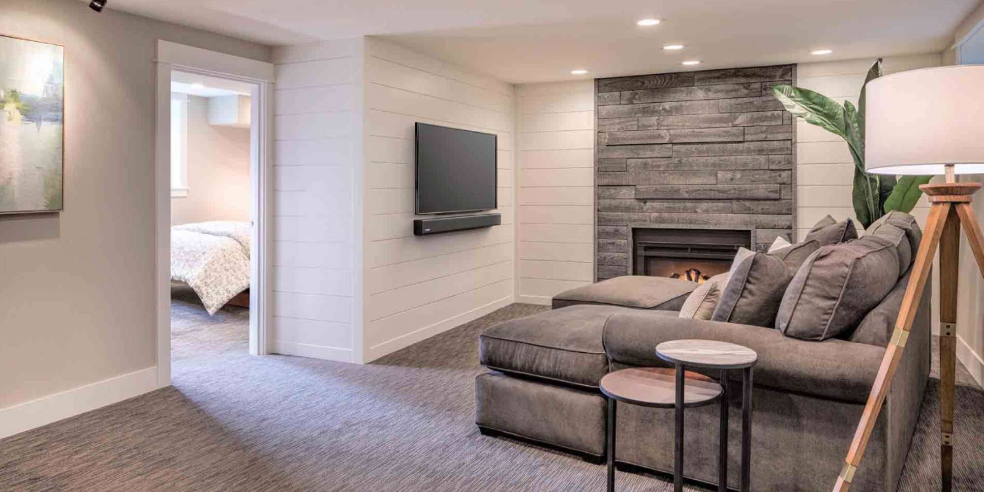 Finished basement remodel in Portland, OR featuring modern fireplace, sectional seating, and entertainment space