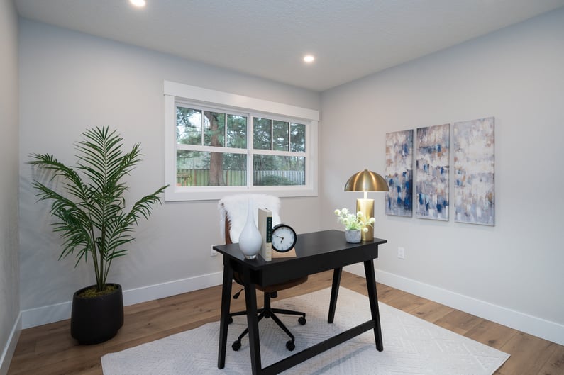 Home office with a sleek black desk and natural light in a whole home remodel by Creekstone Design + Remodel in Raleigh Hills, OR