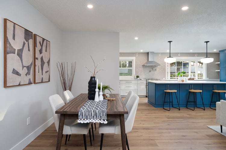 Open floor plan showing dining area and blue kitchen island in a whole home remodel by Creekstone Design + Remodel in Raleigh Hills, OR