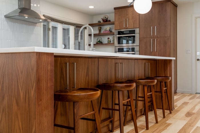 A beautifully crafted kitchen island with wood cabinetry and barstools, designed for a whole home remodel in Portland, OR by Creekstone Design + Remodel