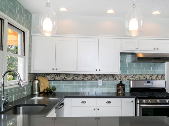 Modern-Kitchen-with-Stainless-Range-Bubble-Glass-Pendant-Lights-Herringbone-Accent-tile-Counter-to-Ceiling-Teal-Subway-Tile-Backsplash-Black-Counters-Side (1)