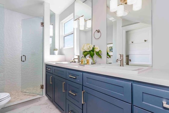 Custom bathroom remodel featuring blue cabinetry and a walk-in shower by Creekstone Design + Remodel in Portland, OR