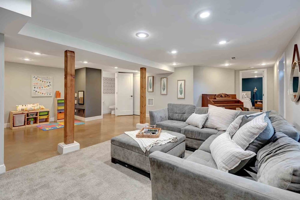 A basement remodel featuring an open layout with seating and a children's play area