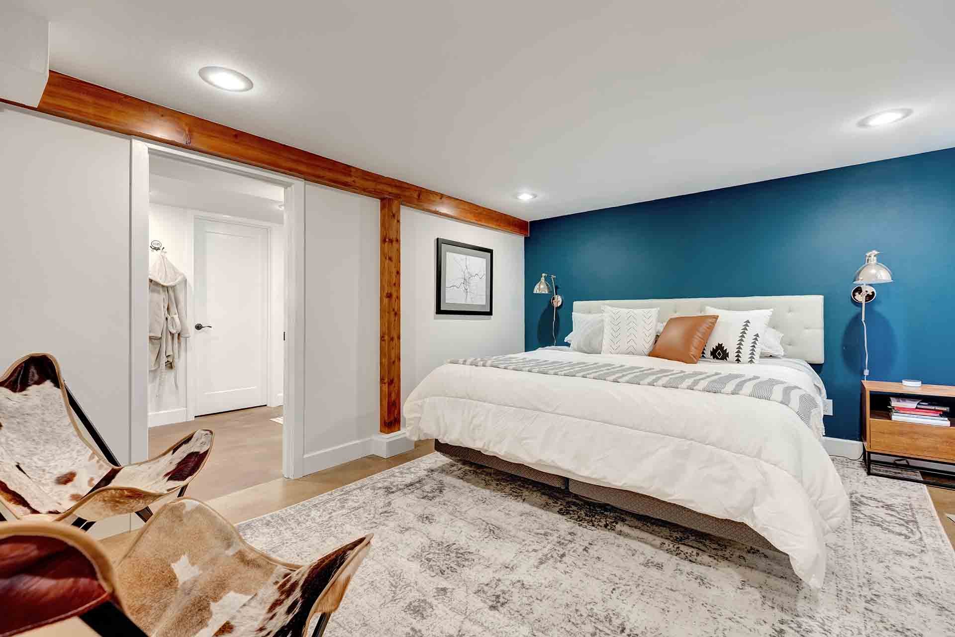 Custom remodeled basement in Portland, OR featuring guest room with statement blue wall 