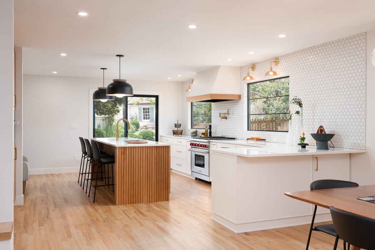Modern kitchen with wood island and matte black pendant lighting from a kitchen remodel in Hillsdale, OR by Creekstone Design + Remodel