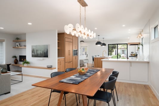 Open-concept dining and kitchen space with modern lighting in a Hillsdale, OR kitchen remodel by Creekstone Design + Remodel