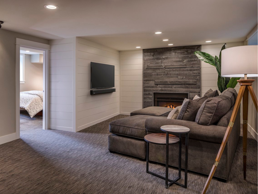 Basement entertainment space in Portland, OR with view into bedroom