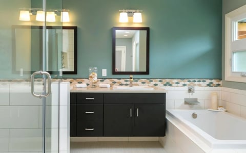 teal bathroom with suspended vanity, soaking tub, walk in bathroom.
