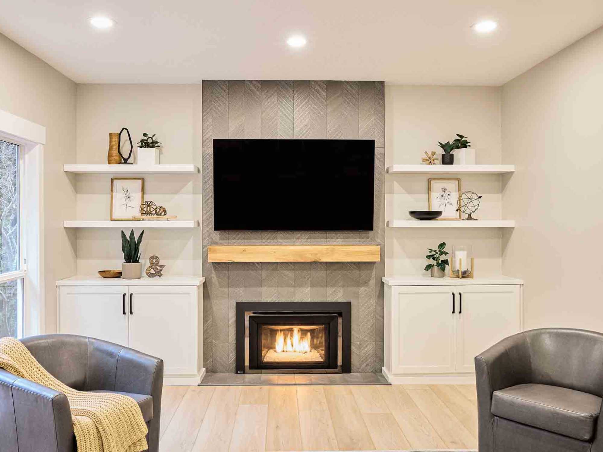 Image of a fireplace with tiling and custom shelving in a remodeled home in Portland, OR by Creekstone