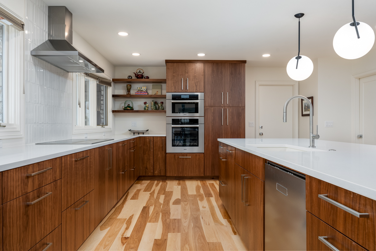 A contemporary kitchen with a large island, stainless steel appliances, and custom wood cabinetry, designed for a whole home remodel in Portland, OR by Creekstone Design + Remodel