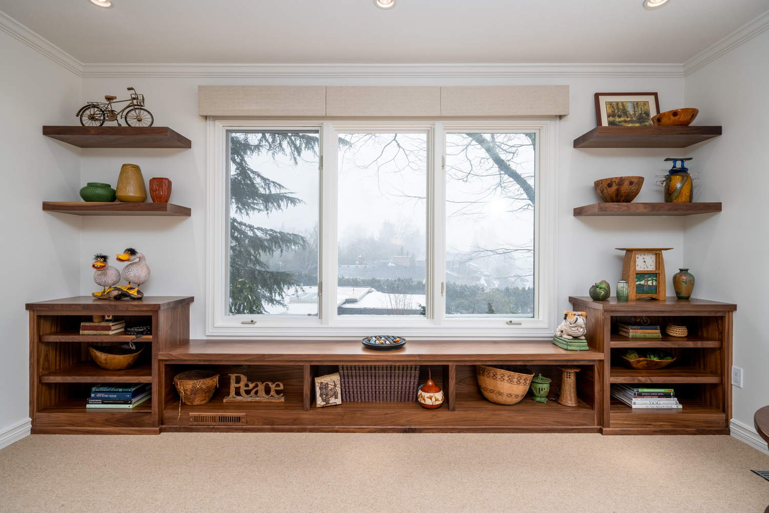 Built-in wooden shelves surrounding a large window with natural light, part of a whole home remodel in Portland, OR by Creekstone Design + Remodel