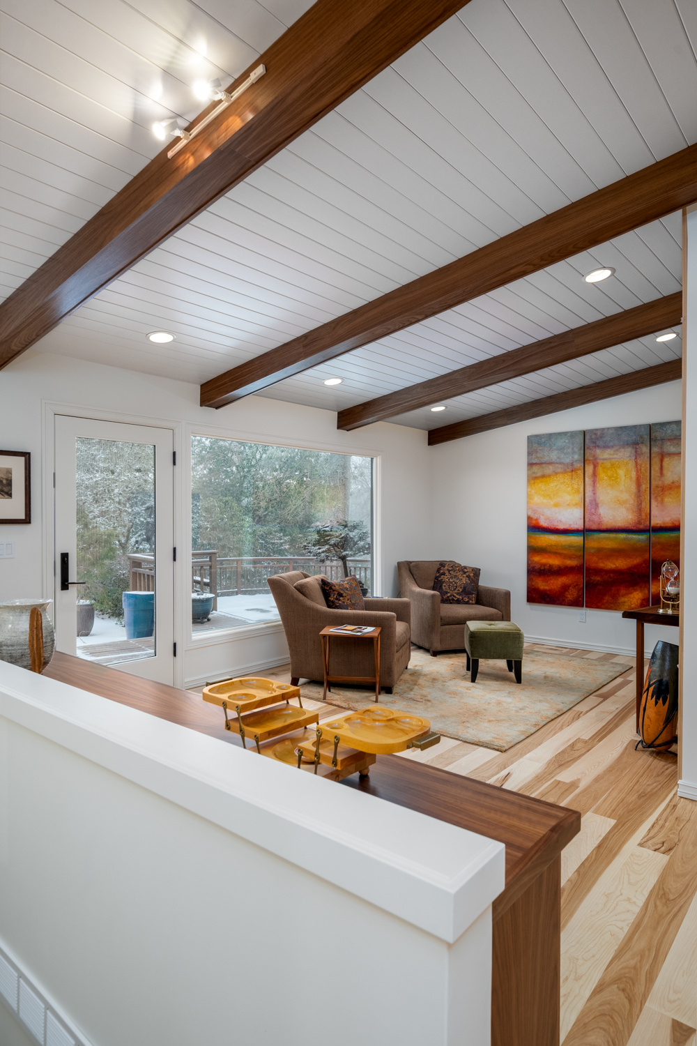 Cozy den corner with modern furniture and a snowy outdoor view, part of a whole home remodel in Portland, OR by Creekstone Design + Remodel.