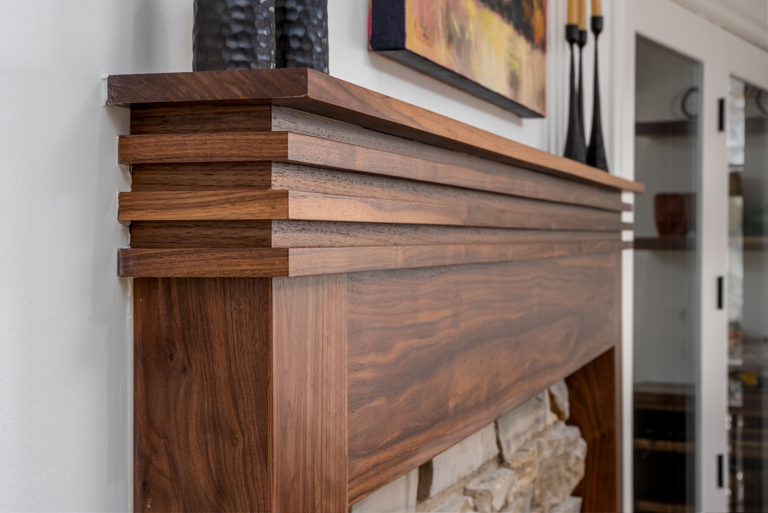 Detailed craftsmanship of a modern wood fireplace mantel with clean lines, part of a whole home remodel in Portland, OR by Creekstone Design + Remodel