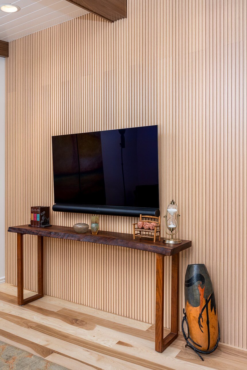 Detailed view of a modern TV area with handcrafted wood accents, included in a whole home remodel in Portland, OR by Creekstone Design + Remodel.