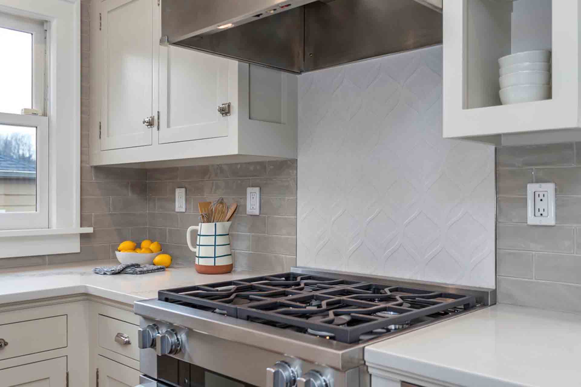 stove and hood with tile backsplash