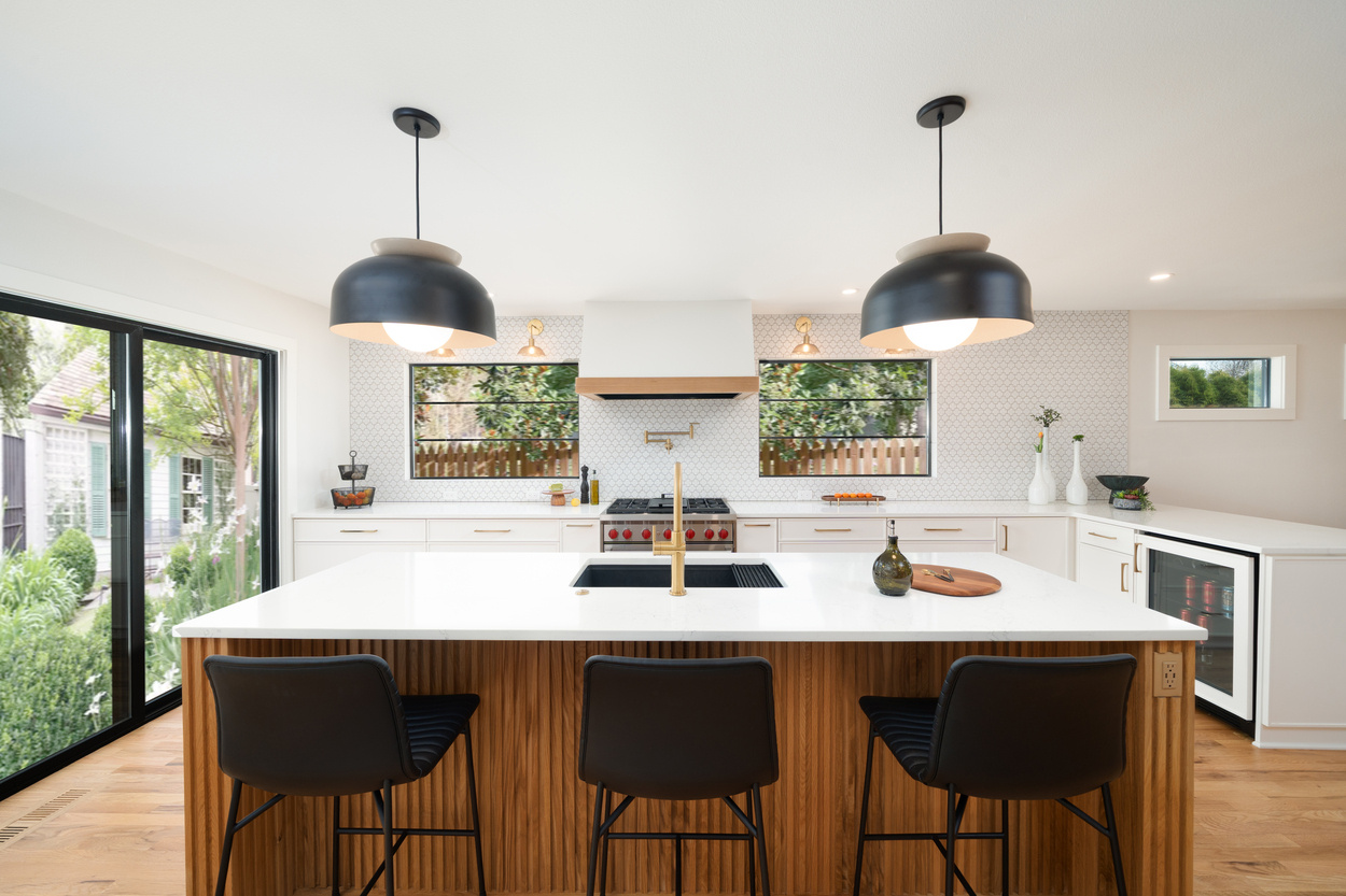 Bright kitchen with white quartz island and dual pendant lighting in Hillsdale, OR by Creekstone Design + Remodel