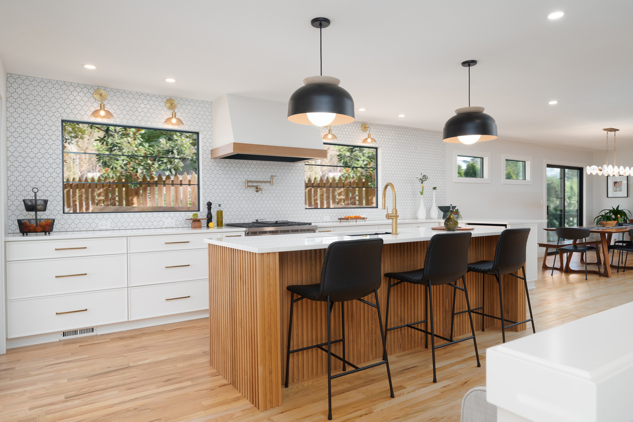 Open kitchen layout with slatted wood island and patterned tile backsplash in Hillsdale remodel by Creekstone Design + Remodel